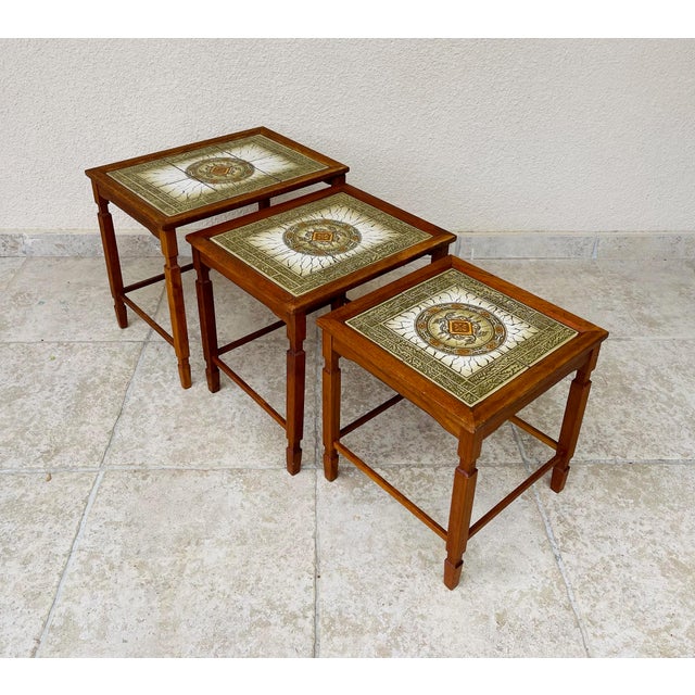 Stunning set of three scandinavian nesting tables, made in denmark in the 1960s. solid teak wood frame with clean lines...