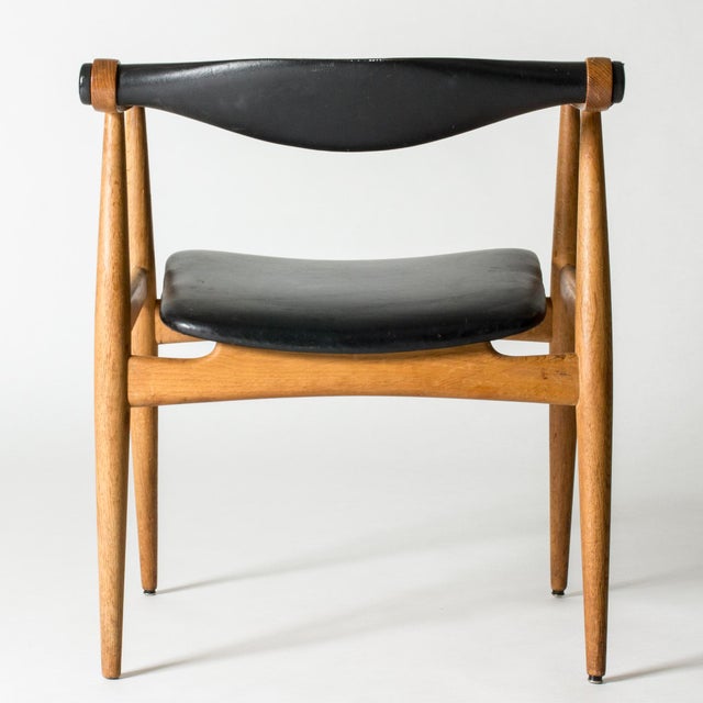 “Yoke” armchair by Hans J. Wegner, made from oak with a black leather back and seat. Striking silhouette with cool details...
