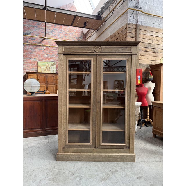 This antique solid oak display cabinet has been fully restored. It features two large, lockable glass doors that open to...