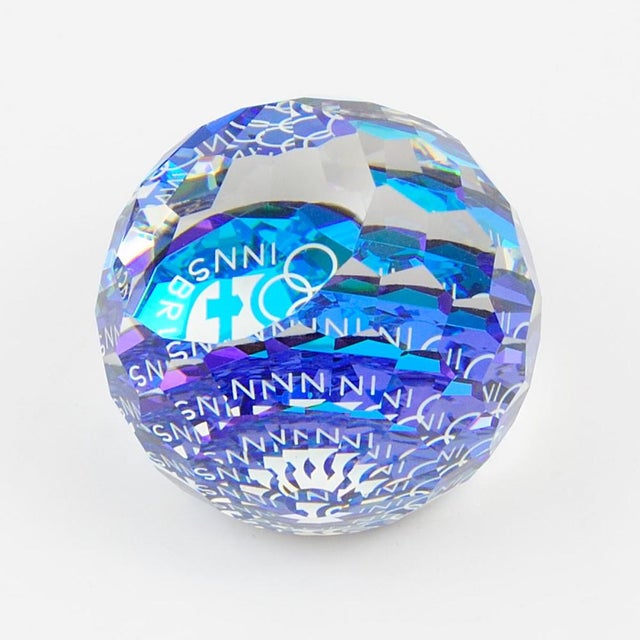 This multi-faceted crystal sphere paperweight was made by Swarovski to commemorate the 1976 Winter Olympics in Innsbruck....