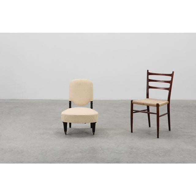 A graceful Napoleon III low chair from 19th‑century France, newly reupholstered yet retaining the charm and character of...