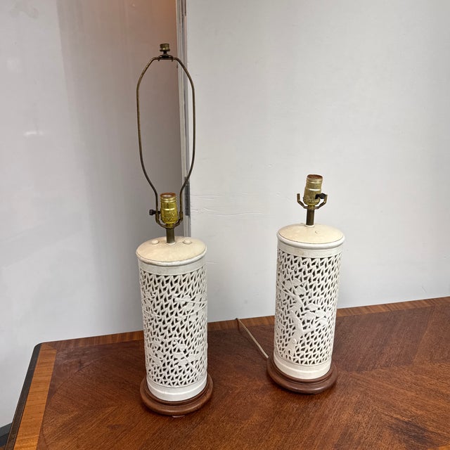 Design Plus Gallery presents a Pair of Chinoiserie Style Pierced Ceramic Table Lamps. Each lamp has a cylindrical cream...