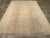 An antique Turkish Oushak room size carpet. A light open field is centered by a flattened diamond medallion and is framed...