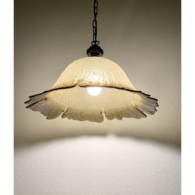 Hand-blown crystal glass in brown, clear, and yellow, shaped like a delicate flower. Features a brass lampshade holder,...