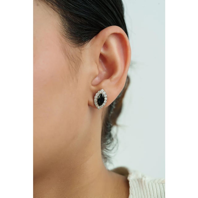 These halo stud earrings showcase 3.32 carats of natural blue sapphires, set in 14k white gold. Each sapphire measuring...