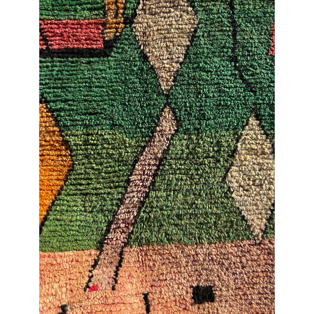 This contemporary Moroccan Boujad rug features a bold abstract composition dominated by rich green tones, accented with...
