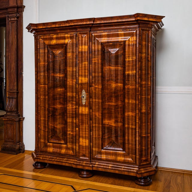 Large Baroque serpentine armoire with chamfered corners and a projecting, richly molded flat cornice. The cabinet stands...