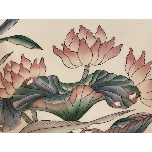 This beautiful plate tells a story of a bird visiting a pond. As she perches above a group of swaying lotus blossoms, she...