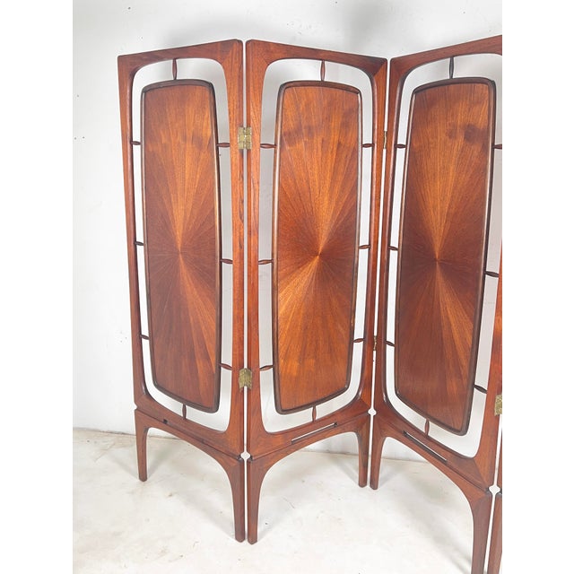 A Danish four-panel folding screen / room divider in teak, circa 1960s. The teak on one side features a radiating...
