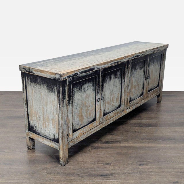 Inspired by European antiques, a distressed black finish and copper-clad hardware are featured in this pine media console....
