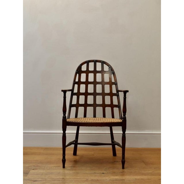 Oak armchair with pierced fretwork back and woven cane seat. A well-crafted vintage chair with timeless design and...