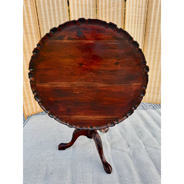 A classic Chippendale-style tilt-top tea table crafted from rich mahogany, featuring a generously sized 39 3/4” diameter...