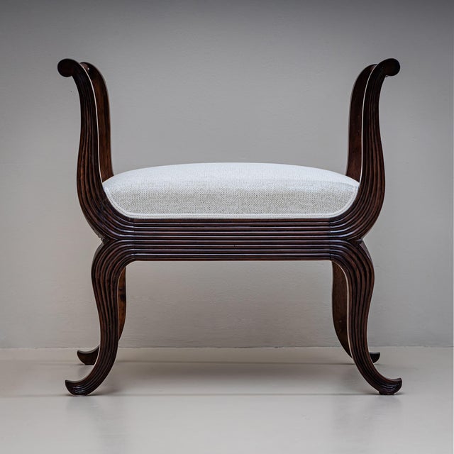 Pair of tabourets crafted from walnut, featuring curved armrests and legs with fluted details. The armrests are connected...