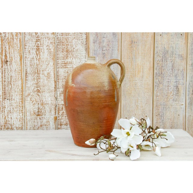 Charming early to mid 20th century clay jug from the Normandy coastline in France. This antique jug was used to store and...