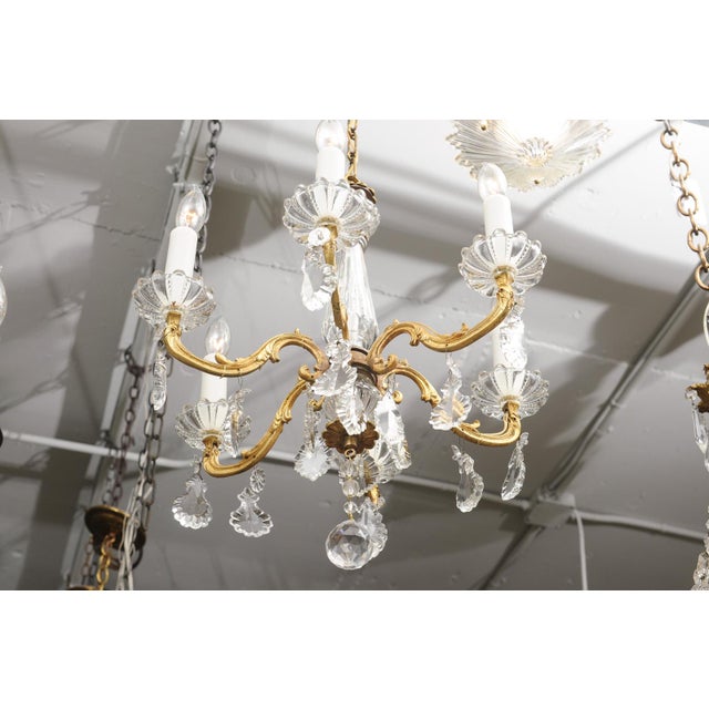 A graceful French Louis XV-style chandelier featuring an elegant combination of finely cast gilt bronze, hand-cut crystal,...