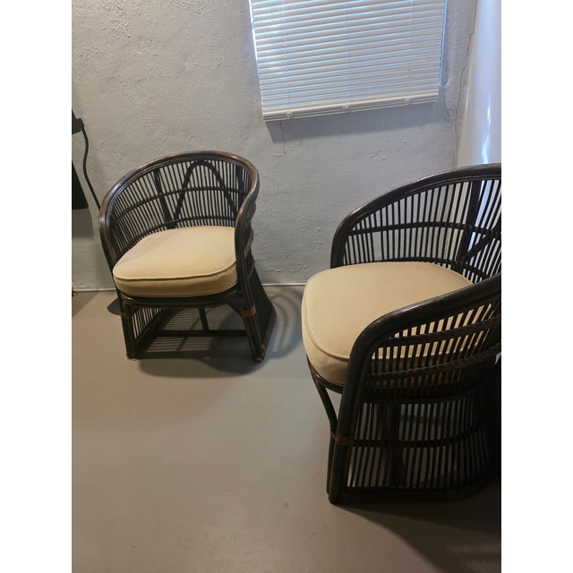 These barrel back rattan chairs represent a popular mid-century design style that flourished from the 1960s through the...