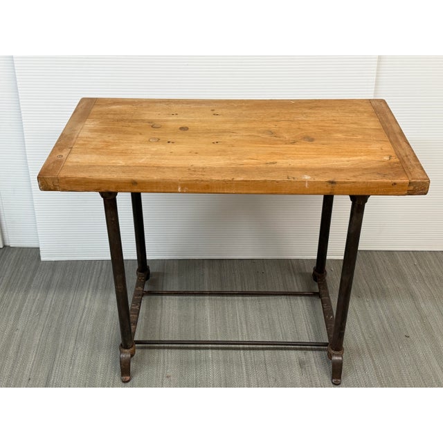 Design Plus Gallery presents a Bewick Industrial Table. The rectangular wood top displays natural grain variation, visible...