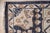 A 9' x 12' hand-knotted wool rug with a bold Heriz-style geometric medallion in navy and ivory on a charcoal gray ground....