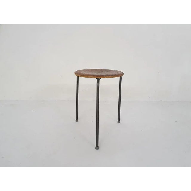 Teak veneer stool on a dark grey metal base. Inspired by the "dot" stool from Arne Jacobsen for Fritz Hansen. Marked "Made...