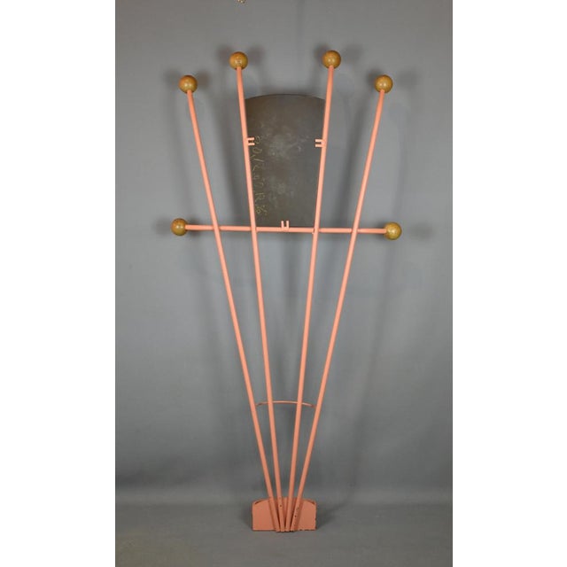 A striking 1940's coat rack design with a central removable mirror plate. Painted in a light salmon pink. At each end of...