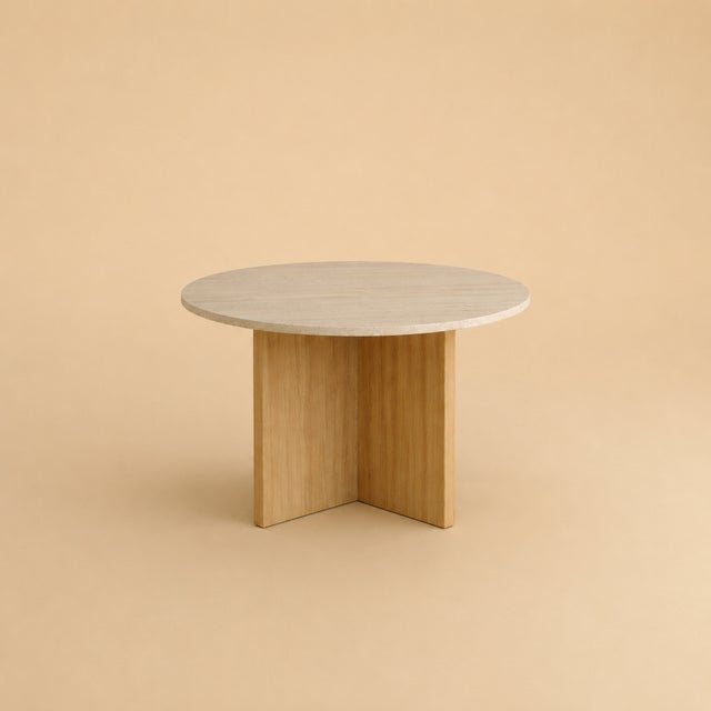 The Hakata is a Roman travertine and oak dining table, a table scaled for a room and its company. Stone and timber are set...