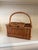 A beautifully woven vintage wicker picnic basket featuring a generous arched carrying handle, hinged lid with leather...