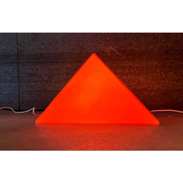 Postmodern prism-shaped floor/table lamp by Heico. Shown here in orange. These lamps feature the graphic form of a prism....