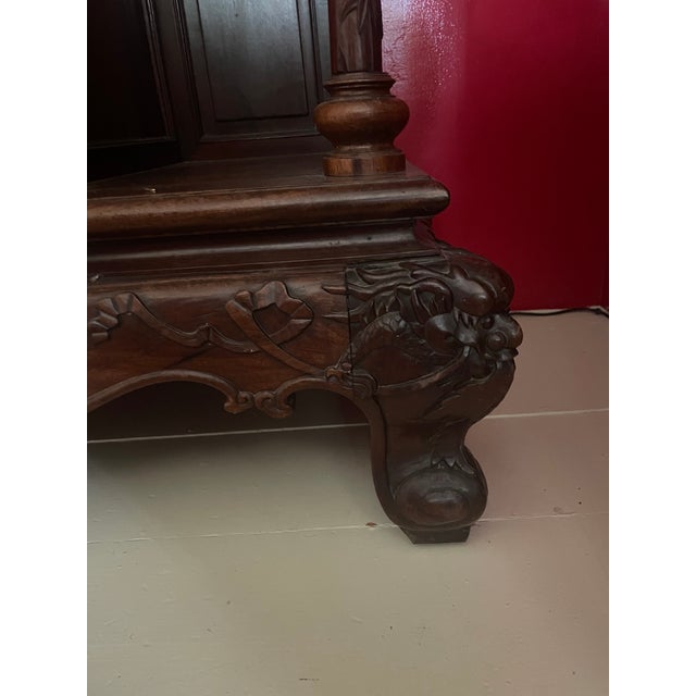 Heavily carved, Chinese rosewood display cabinet with three levels. Base has carved apron and squat legs. Mid-section has...