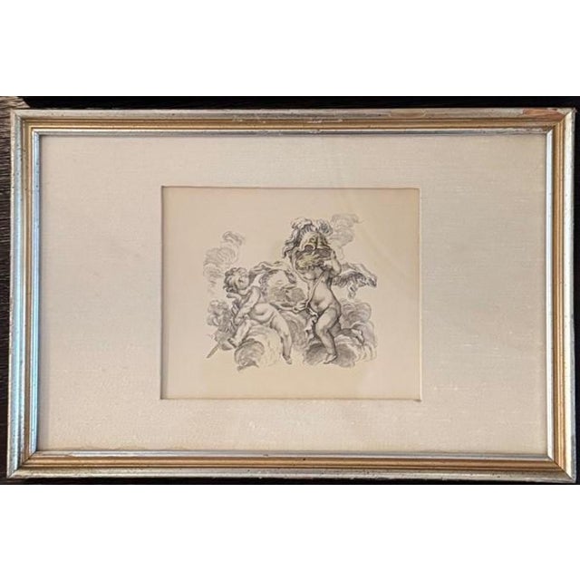 A charming set of three framed Neoclassical-style engravings depicting playful cherubs (putti) in dynamic classical...