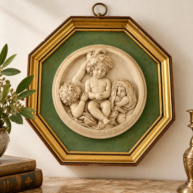 An elegant mid-20th-century decorative relief medallion by Sungott Art Studios of New York, reproducing The Infant...