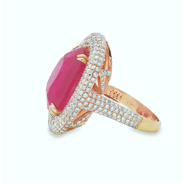 Centering a 23.61 carat natural Burmese ruby, this striking cocktail ring showcases a richly colored cushion-cut gemstone...