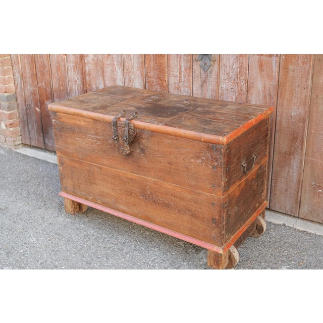 Originally a Dowry chest made from teak wood, stands on wooden caster legs, iron side handles and nail head details, it...