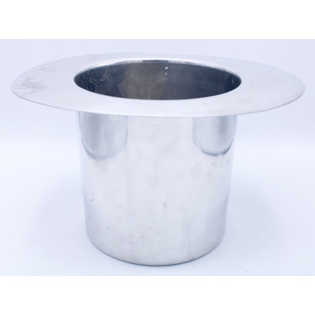 A superb vintage chrome ice bucket in the shape of a top hat by Kate Spade, with the inscription “Bottoms Up,” circa...