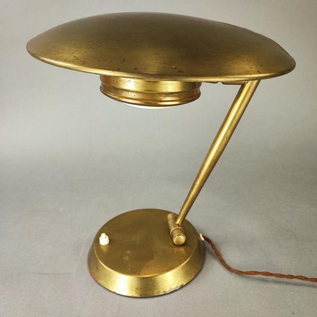 Italian table lamp with a classic and elegant 1950s design. Brass structure with adjustable arm, shade, and plate. Good...