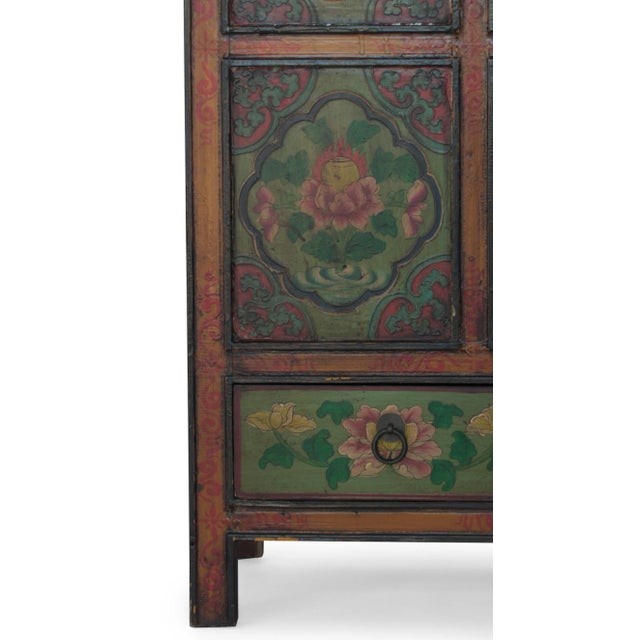 A Tibetan cabinet, hand-built with traditional joinery and painted with multi-colored floral decoration. The cabinet...