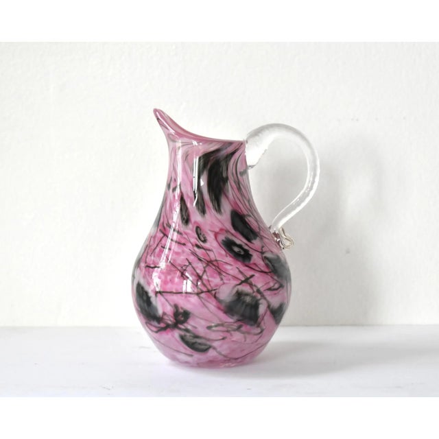 A vintage, mid-century Italian, Murano art glass pitcher, with an abstracted pink and black millefiori design and a clear...