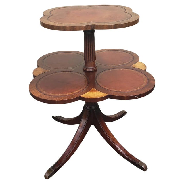 Two-tier mahogany and walnut with satinwood inlays and leather top dumbwaiter Good vintage condition. Stenciled leather...