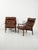 Pair of Danish armchairs in dark lacquered beech and brown leather, with a high backrest featuring curved slats and...