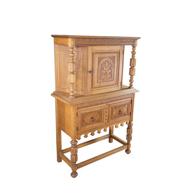 Vintage Jacobean revival court cupboard. Made from quartersawn oak with an upper hutch mounted between two beautifully...