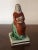 Antique early 19th c. English pearlware figure of a woman sitting atop rockwork and wearing a red cloak with a basket of...