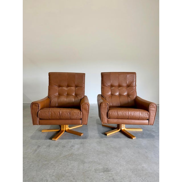 Vintage 1970’s Caramel Leather and Beech Wood Swivel Lounge Chair Pair. Cowboy/Baseball glove leather stitching details...
