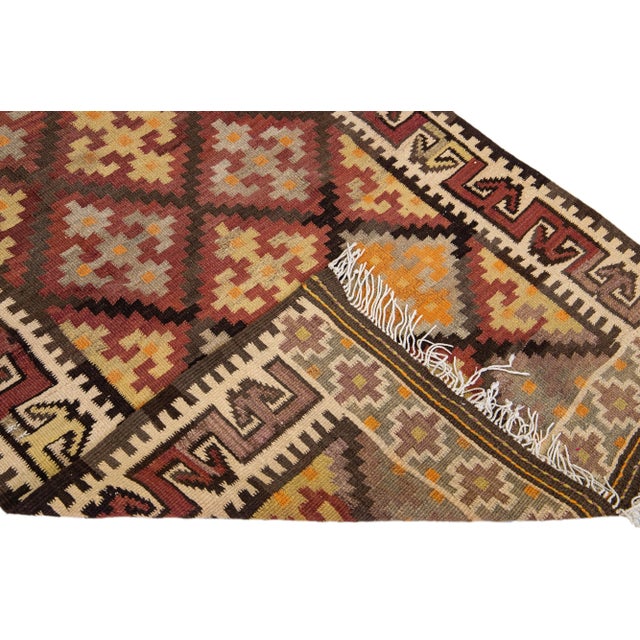 Beautiful vintage Turkish Kilim hand-knotted wool runner with an orange field. This rug has a beige frame and multicolor...