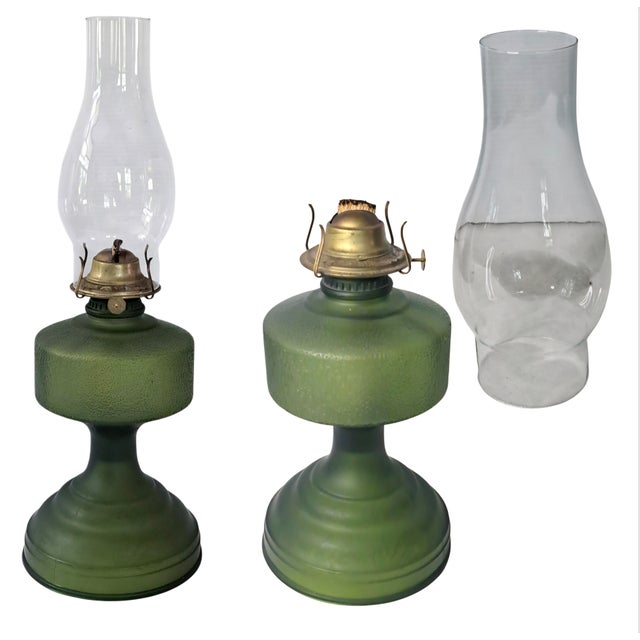 A striking vintage kerosene oil lamp featuring a rich forest-green textured pebble-glass base, clear hurricane chimney,...