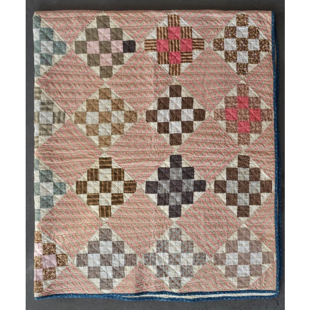 A nine-patch variation set on point (diamond orientation) alternating with striped blocks with fabric patches from the...