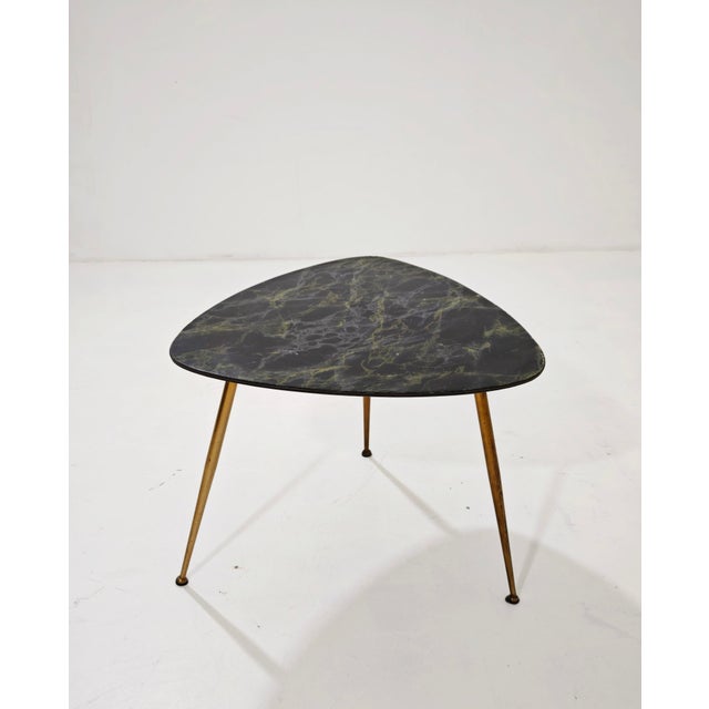 Vintage tripod coffee table dating back to the mid-century modernist period of the 1950s. It features a distinctive...