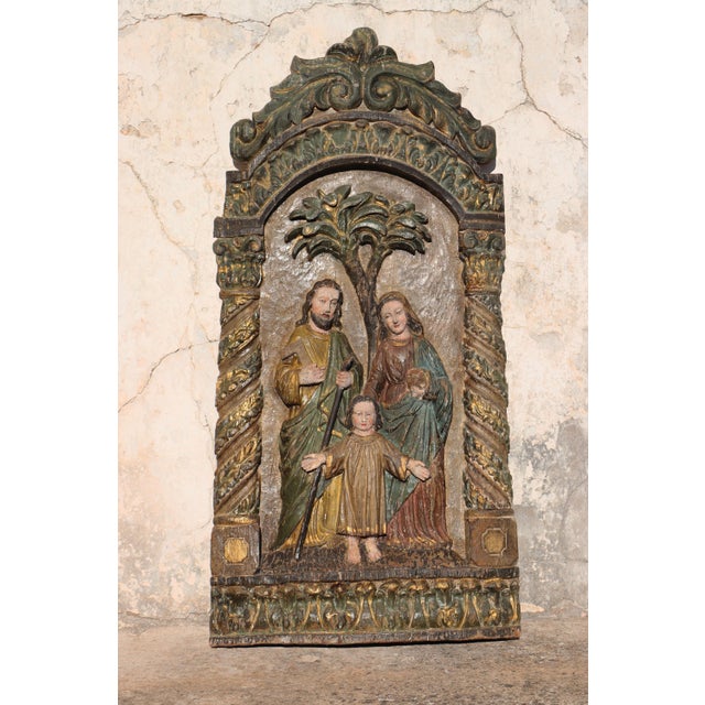 A 17th-century large Baroque wooden Holy Family retable, Portuguese, depicting Saint Joseph holding a saw, the Virgin Mary...