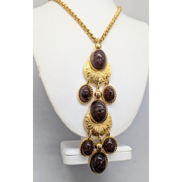 1970s goldtone cabochon faux-brown agate with white swirls pendant necklace on a chain with hook clasp. Marked "LES...