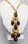 1970s goldtone cabochon faux-brown agate with white swirls pendant necklace on a chain with hook clasp. Marked "LES...