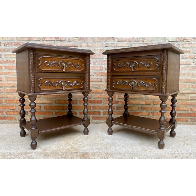 20th century pair of solid carved French nightstands with turned columns, two drawers and one low shelve. It has two...