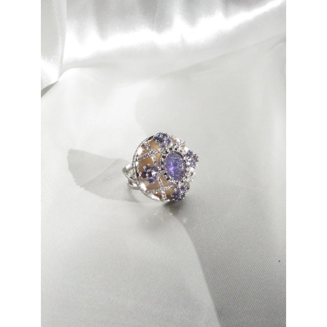 This unique Tutti Frutti Art Deco cocktail ring showcases a striking natural carved Tanzanite center complemented by...